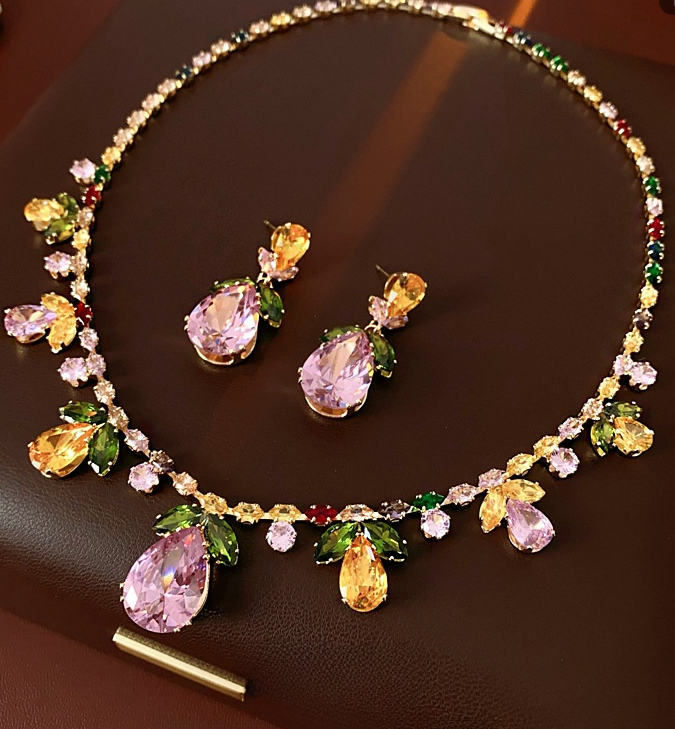 Elegant 18k gold-plated jewelry set with colorful zirconia in a floral and leaf design, featuring a statement necklace and coordinating drop earrings.